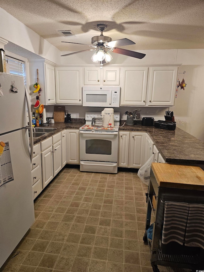 Kitchen with ceiling fan, dark tile patterned floo