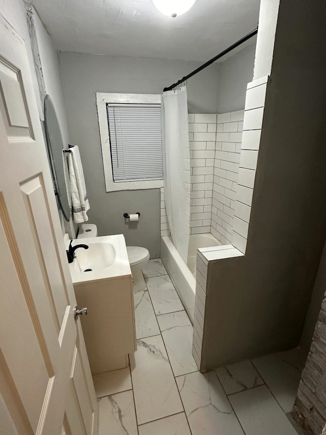 Full bathroom featuring shower / tub combo, vanity, and toilet