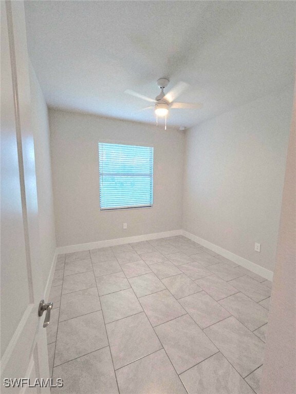 Unfurnished room featuring a ceiling fan and light