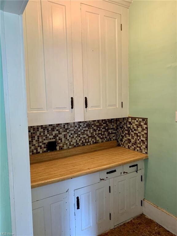 Kitchen pantry area featuring white cabinets, back