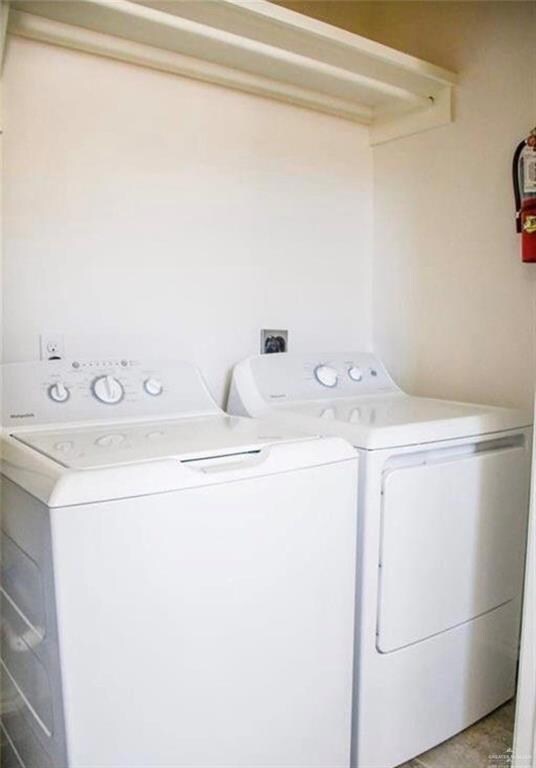 Laundry area featuring independent washer and dryer and light tile patterned flooring