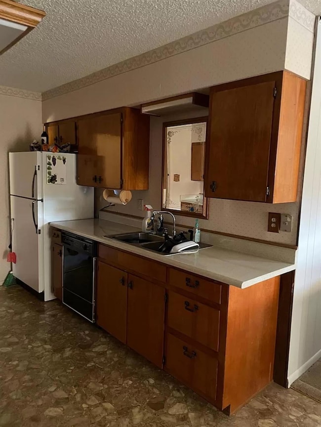 Kitchen with dishwasher, a textured ceiling, ligh