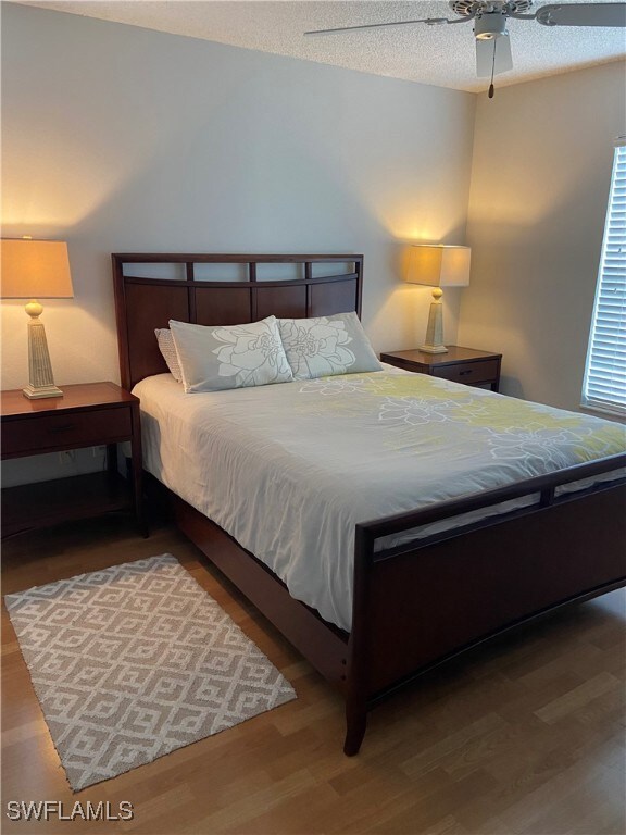 Bedroom featuring a textured ceiling, wood finishe