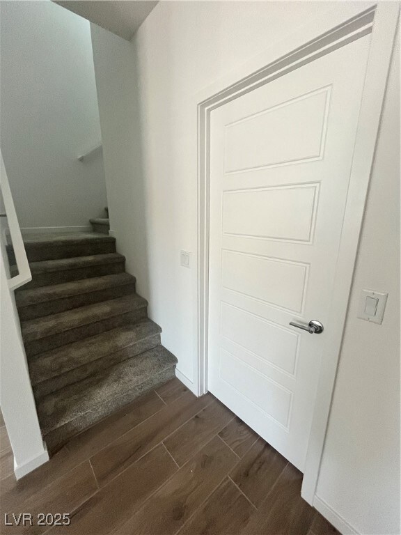 Stairs featuring wood finished floors