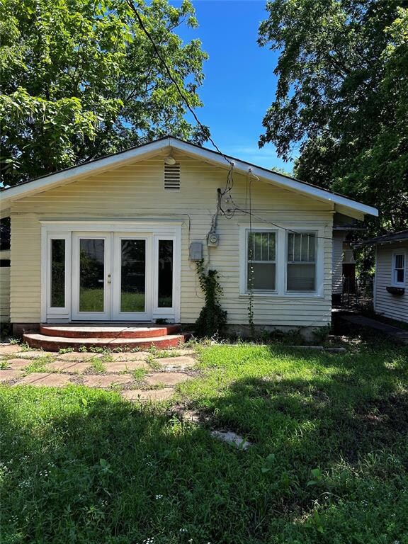 Back of property featuring french doors and a yard