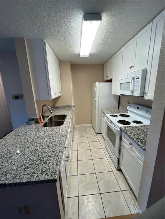 This kitchen features granite countertops, white c