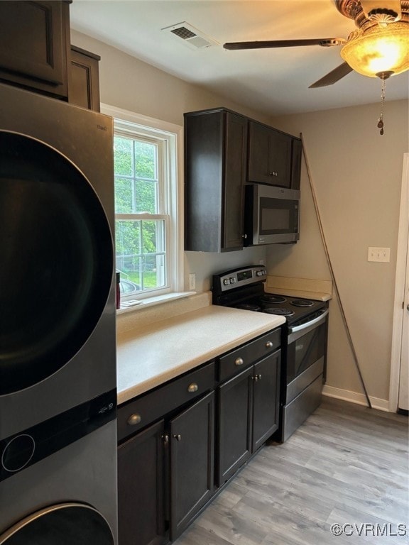 Kitchen with stove, a ceiling fan, light counterto