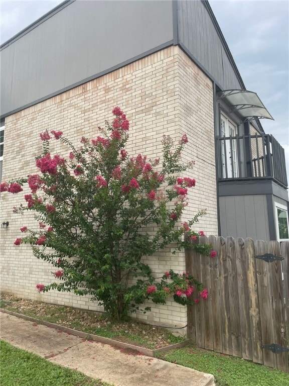 View of property exterior with brick siding and a balcony