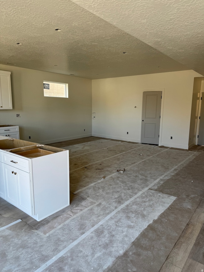 Kitchen featuring white cabinetry and a textured ceiling