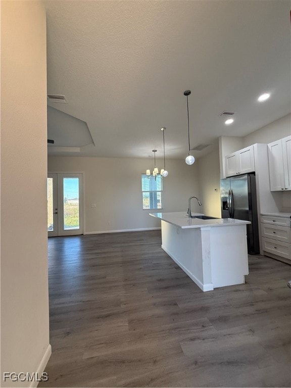 Kitchen featuring open floor plan, pendant lighting, white cabinets, light wood-style floors, and recessed lighting