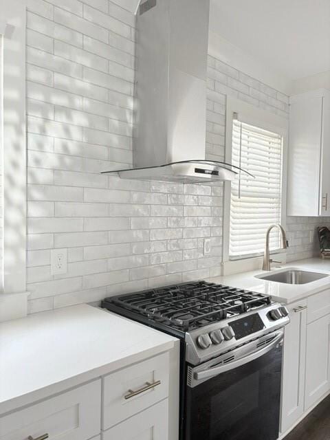 Kitchen with stove, range hood, a sink, white cabi