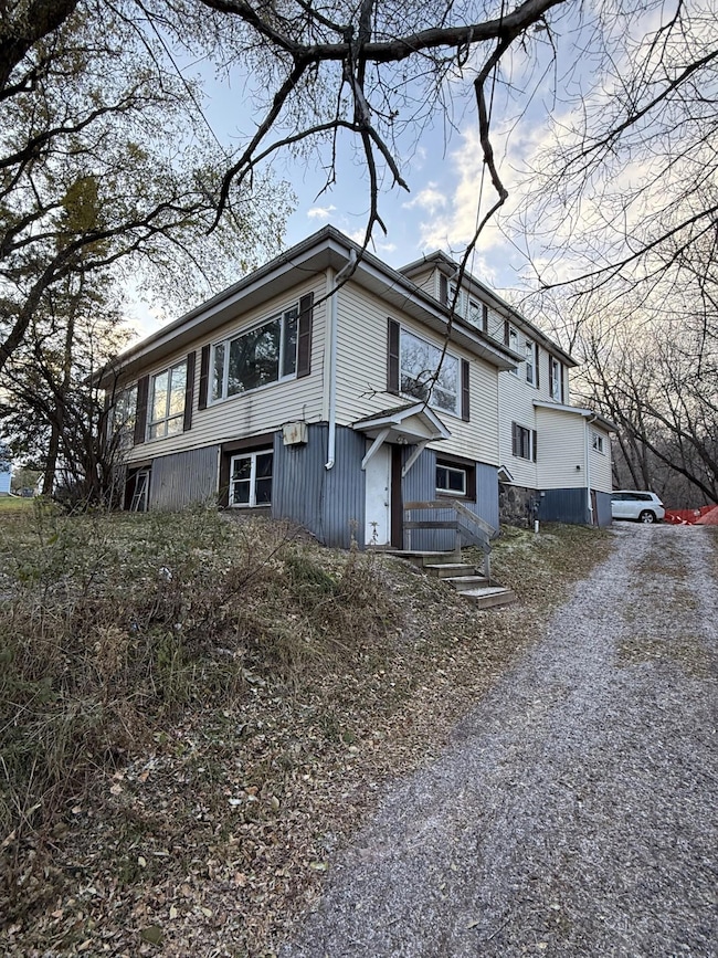 View of side of home featuring gravel driveway