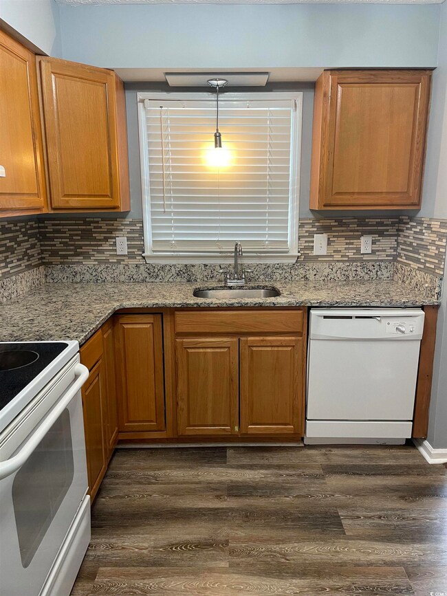 Kitchen featuring sink, tasteful backsplash, dark 