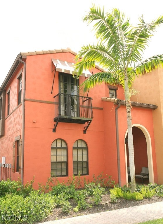 View of side of home with a balcony and stucco siding