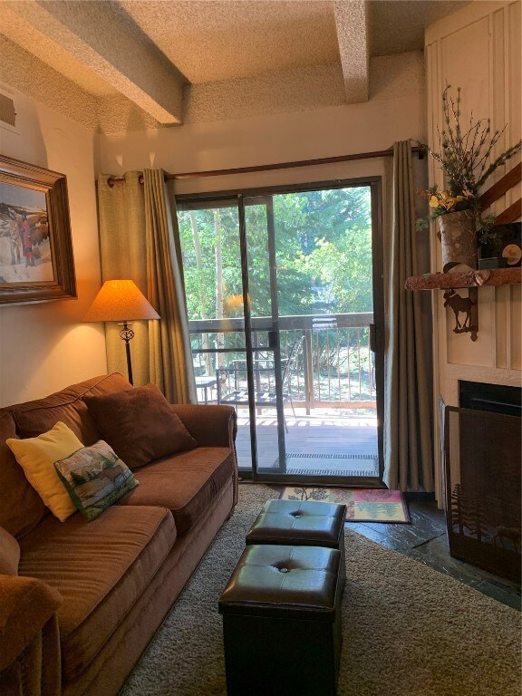 Living area featuring a large fireplace and beam c