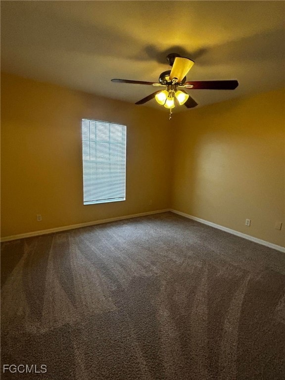 Spare room with dark carpet and baseboards