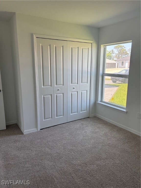 Unfurnished bedroom featuring carpet floors, a clo