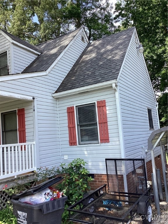 View of side of property with roof with shingles