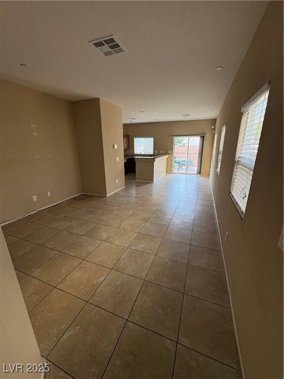 Tiled empty room featuring baseboards
