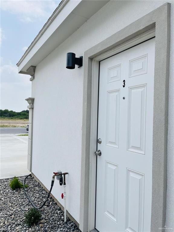 Entrance to property with stucco siding