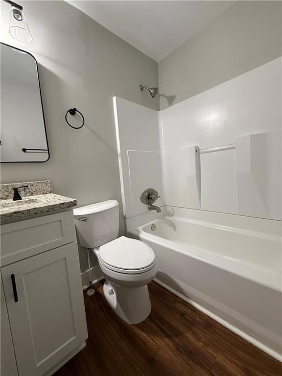 Bathroom featuring dark wood-style flooring, vanity, and shower / bath combination