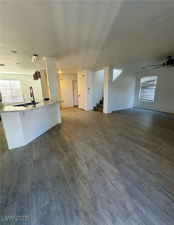 Unfurnished living room with a sink, stairway, dar