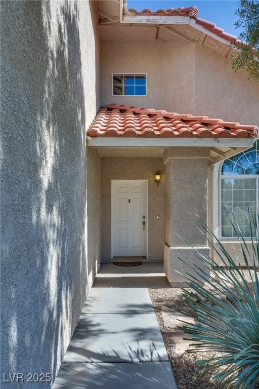 Entrance to property featuring a tiled roof and st