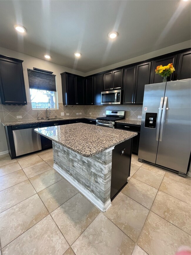 Spacious kitchen with granite countertops and stainless steel appliances.