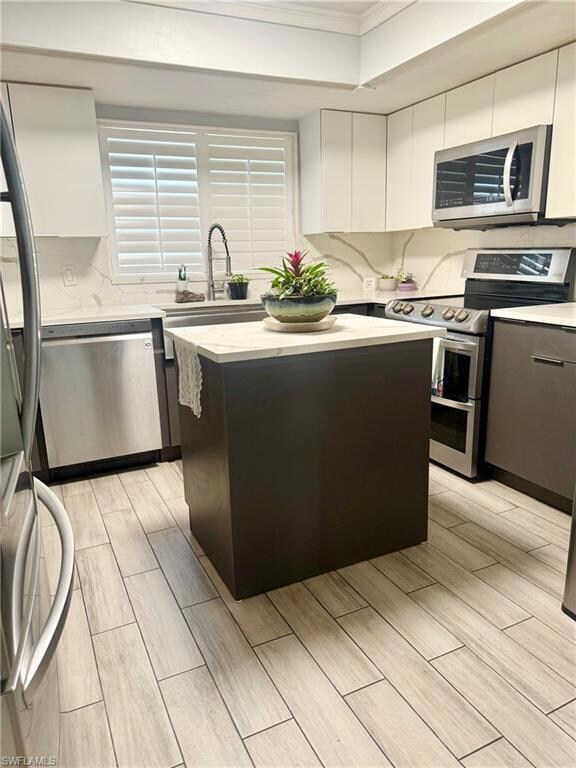 Kitchen featuring a kitchen island, decorative bac