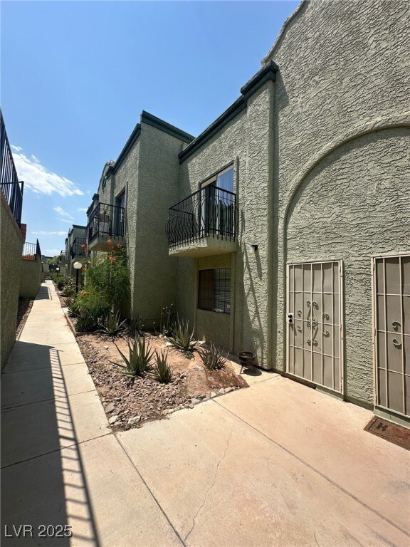 View of property exterior with stucco siding, a ba