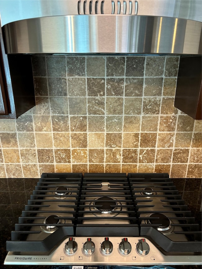 Kitchen view of ventilation hood and stone countertops