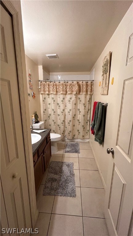 Bathroom featuring tile floors, toilet, and vanity
