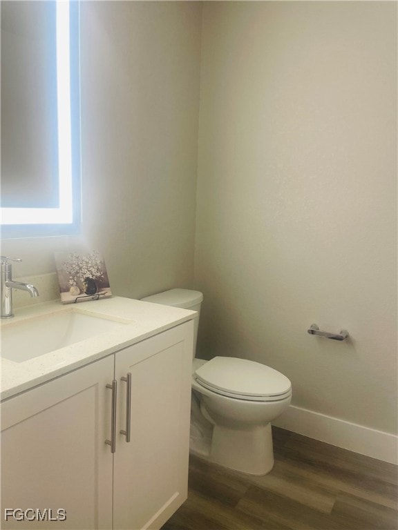 Half bathroom with vanity and dark wood-style floors