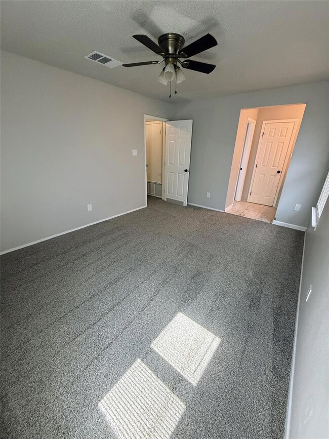 Unfurnished bedroom featuring a textured ceiling and ceiling fan