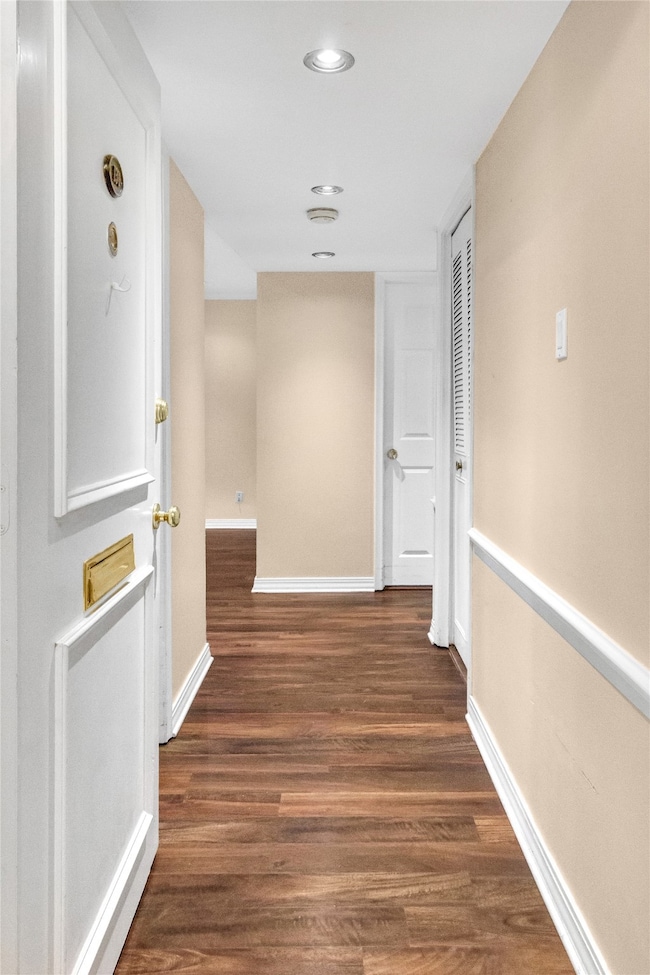 Hall with dark wood-style floors and recessed lighting