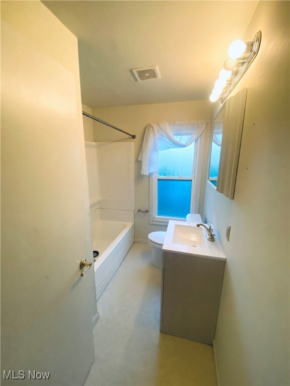 Full bathroom featuring bathing tub / shower combination, vanity, concrete floors, and toilet