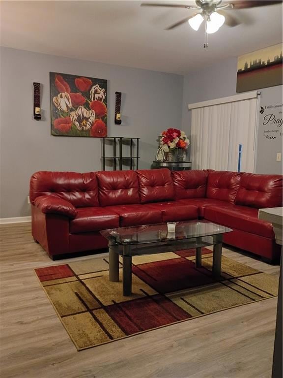 Living room with light wood finished floors and a ceiling fan