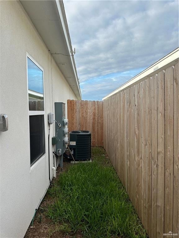 View of yard featuring fence and central AC