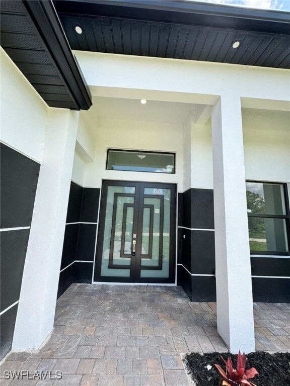 Property entrance featuring french doors and stucc