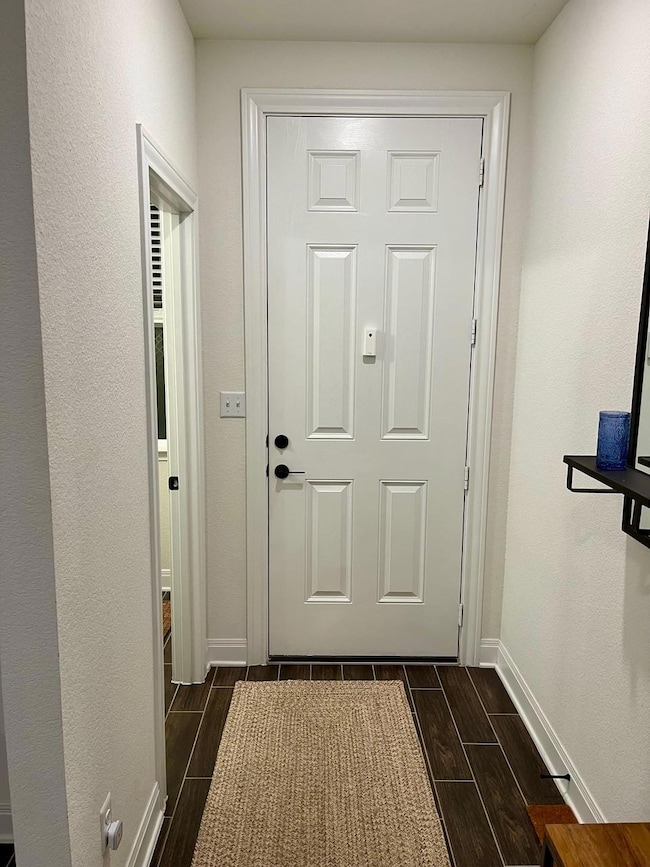 Entryway featuring wood finish floors and baseboa