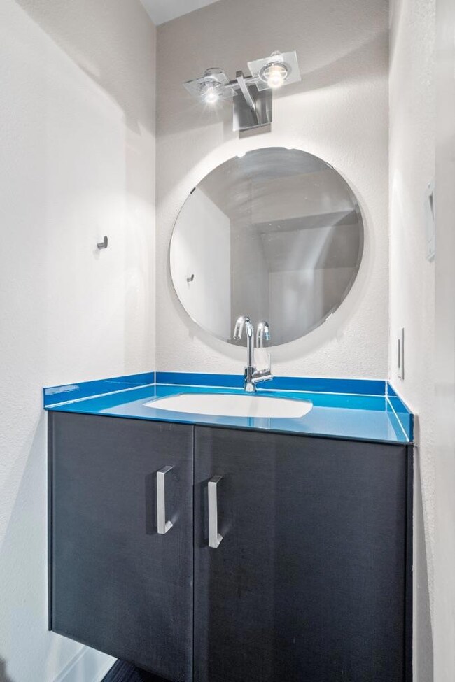 Bathroom with vanity and a textured wall