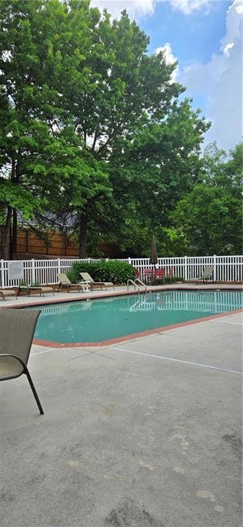 View of pool with fence, a patio area, and a fence