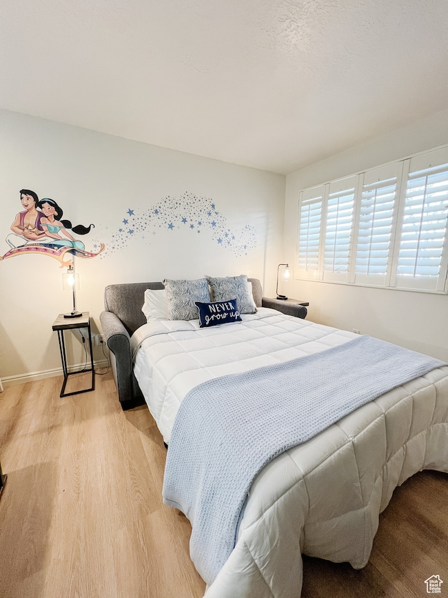 Bedroom featuring wood finished floors and baseboards