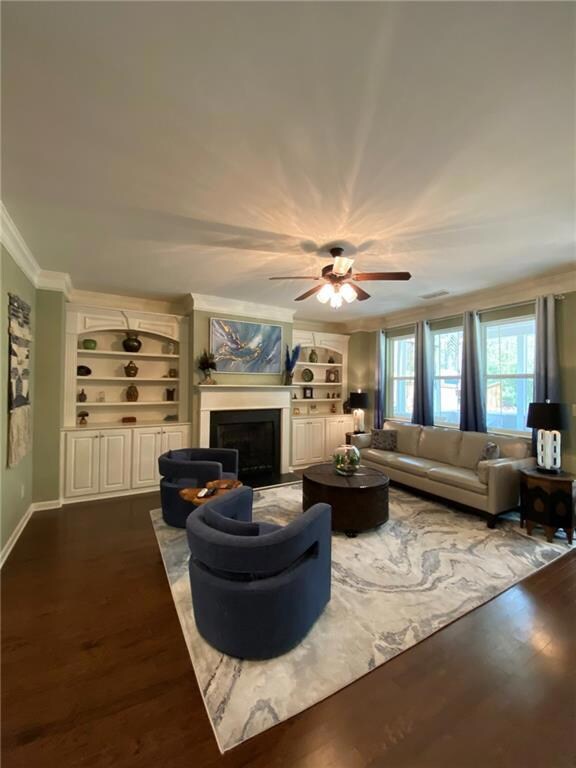 Living room with crown molding, dark wood-style fl