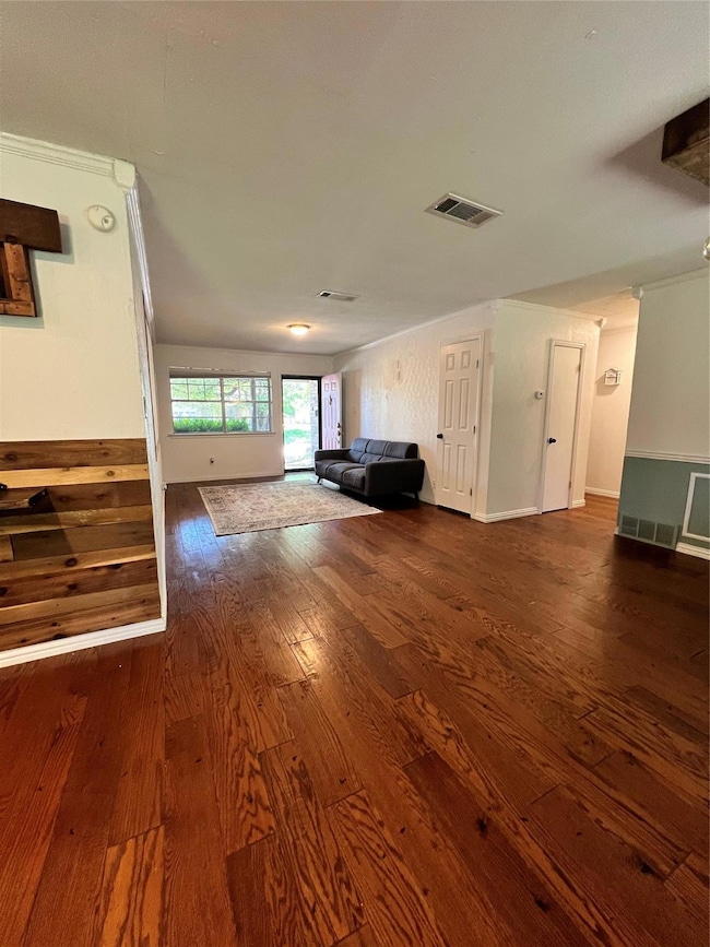 Unfurnished living room featuring wood-type floori