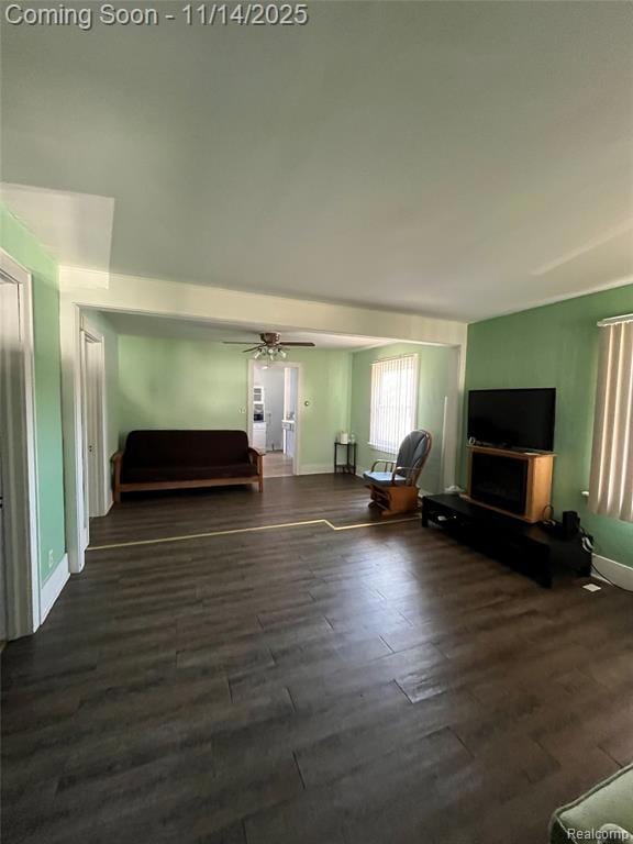 Living room with dark wood-style flooring and a ceiling fan