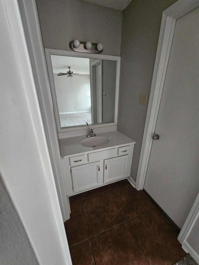 Bathroom with tile patterned flooring, vanity, and a ceiling fan