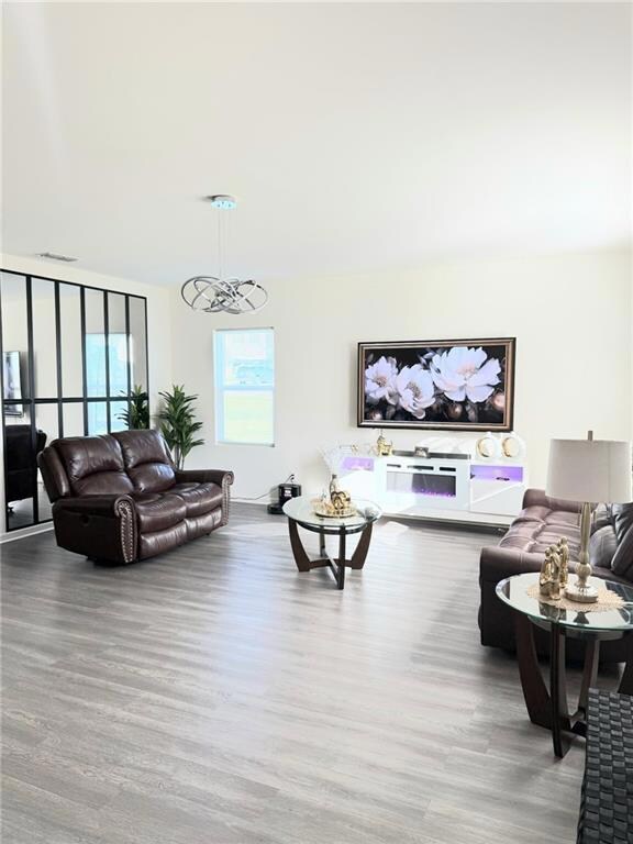Living room with wood finished floors and a chandelier