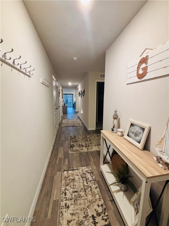 Corridor with dark wood-style floors and baseboard