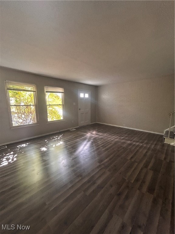 Unfurnished living room with dark wood-style floors and a textured ceiling